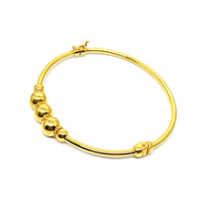 a 21k gold bangle with a clip lock. comfort use. a simple and minimalist design with a ball. design.