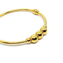 a 21k gold bangle with a clip lock. comfort use. a simple and minimalist design with a ball. design.