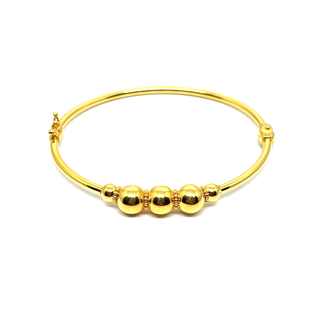 a 21k gold bangle with a clip lock. comfort use. a simple and minimalist design with a ball. design.
